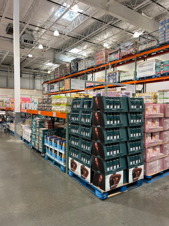A spacious warehouse aisle with shelves full of health products, industrial lighting.