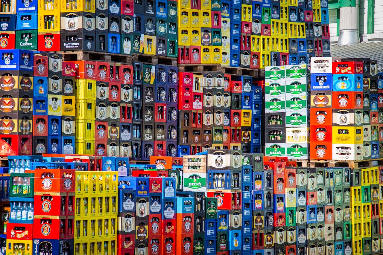 A vibrant display of beer crates stacked in a warehouse, showcasing various brands.